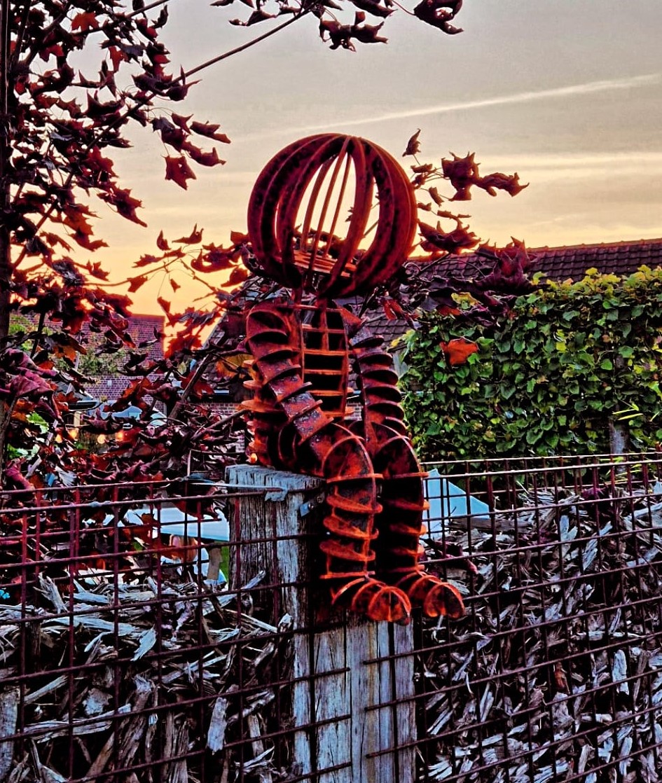 cortenstaal zittende man mascotte